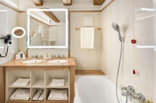 a bathroom with a tub and a sink and a shower at Radisson Blu Hotel Altstadt in Salzburg