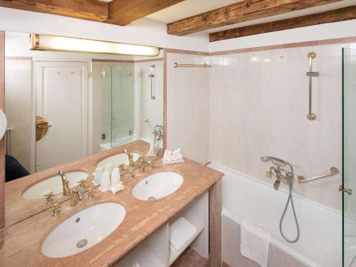 a bathroom with two sinks and a shower at Radisson Blu Hotel Altstadt in Salzburg