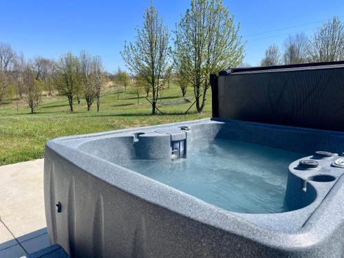 a jacuzzi tub in a backyard with a field at Bourbon Barrel Cottages #2 of 5 on Kentucky trail in Lawrenceburg