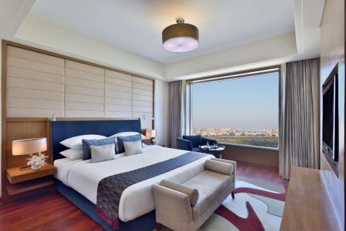 a bedroom with a large bed and a large window at Radisson Blu Hotel, Indore in Indore