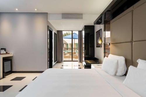 a bedroom with a large white bed and a balcony at Radisson Blu Hotel Lusaka in Lusaka