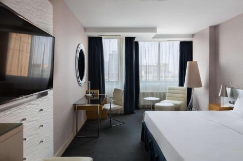 モスクワにあるラディソン ブルー ベラルースカヤのベッド、デスク、椅子が備わるホテルルームです。