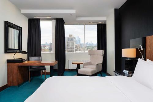 モスクワにあるラディソン ブルー ベラルースカヤのベッド、デスク、窓が備わるホテルルームです。