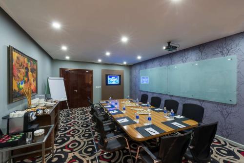 a conference room with a large table and a screen at Radisson Blu Hotel Lusaka in Lusaka