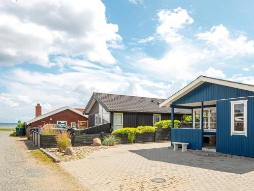 a house with a blue roof on a street at 6 person holiday home in Bjert-By Traum in Binderup Strand
