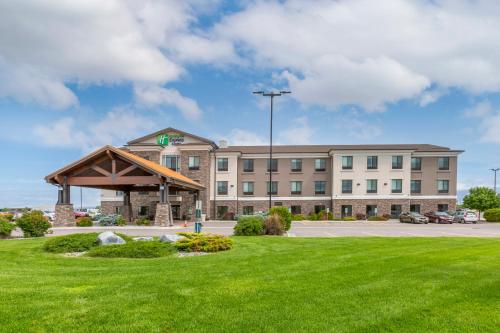 a large building with a green lawn in front of it at Holiday Inn Express Belgrade-Bozeman Area, an IHG Hotel in Belgrade