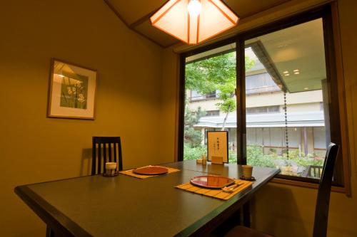 a dining room with a table and a window at Shosenkaku Kagetsu in Yuzawa