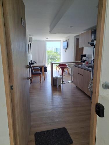 a room with a kitchen and a table with chairs at Lindo apartamento en Santa Marta, Rodadero, Gaira 503 in Santa Marta