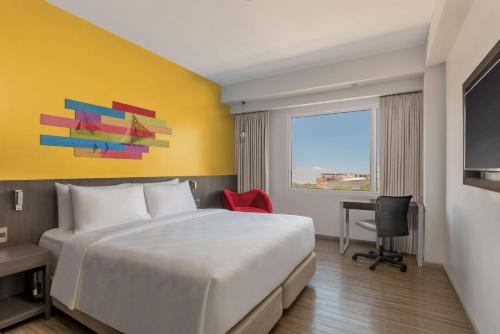 a hotel room with a large bed and a window at Park Inn By Radisson Iloilo in Iloilo City