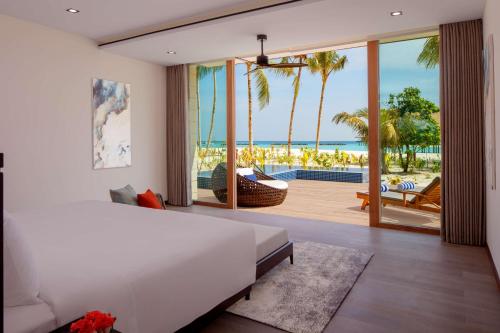 Schlafzimmer mit einem Bett und Meerblick in der Unterkunft Radisson Blu Resort Maldives in Fenfushi