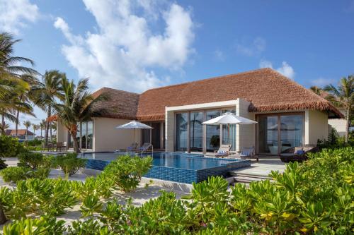 eine Villa mit einem Pool und einem Resort in der Unterkunft Radisson Blu Resort Maldives in Fenfushi
