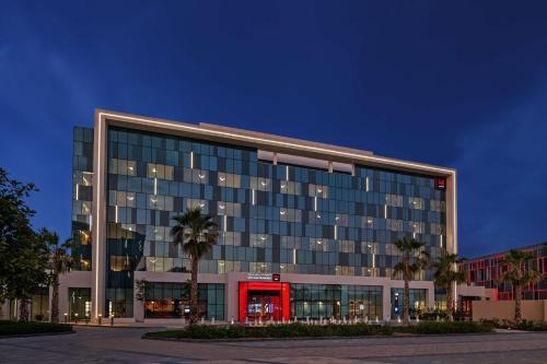 Radisson RED Dubai Silicon Oasis في دبي: مبنى مكتب كبير مع باب احمر