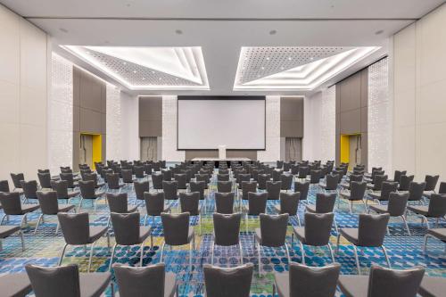 a conference room with chairs and a projection screen at Radisson RED Dubai Silicon Oasis in Dubai