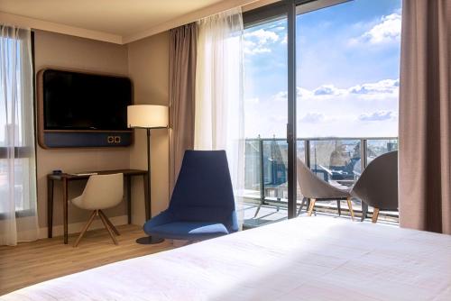 ルーアンにあるRadisson Blu Hotel, Rouen Centreのベッドと大きな窓が備わるホテルルームです。
