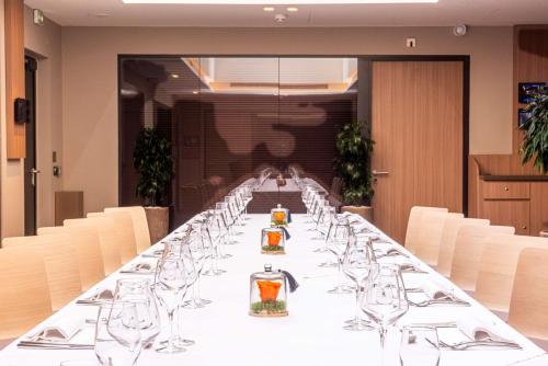 a long table in a room with chairs and glasses at Radisson Blu Hotel, Rouen Centre in Rouen