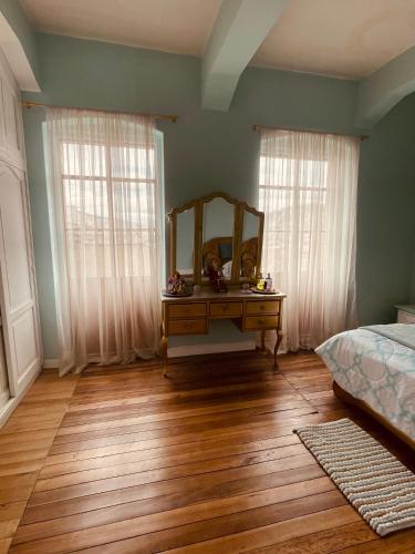een slaapkamer met een kaptafel en een spiegel bij espectacular departamento centro de quito in Quito
