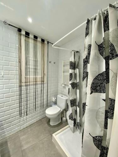 a bathroom with a toilet and a shower curtain at Central Apartment BCN in Barcelona