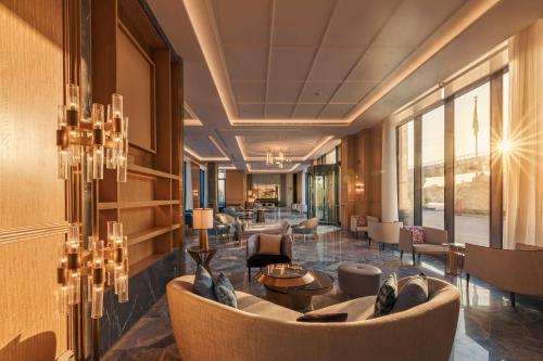 a lobby of a hotel with a couch and chairs at Mansard Riyadh, a Radisson Collection Hotel in Riyadh