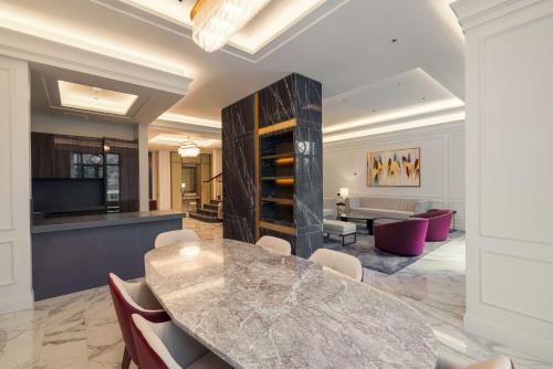 a dining room with a marble table and chairs at Mansard Riyadh, a Radisson Collection Hotel in Riyadh