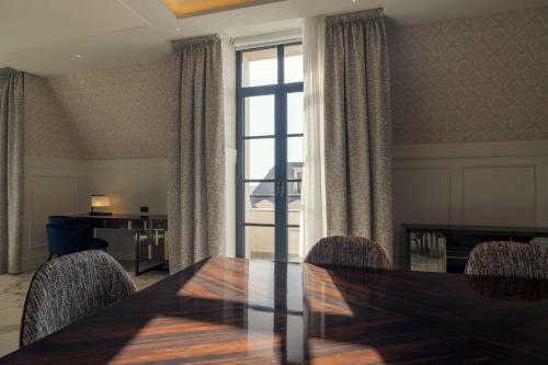 a dining room with a table and chairs and a window at Mansard Riyadh, a Radisson Collection Hotel in Riyadh
