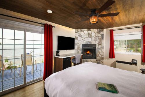 um quarto com uma cama, uma lareira e uma televisão em Bayview Wildwood Resort, Ascend Hotel Collection em Severn