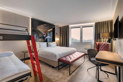 een hotelkamer met een bed en een bureau bij Radisson RED London Heathrow in Harmondsworth