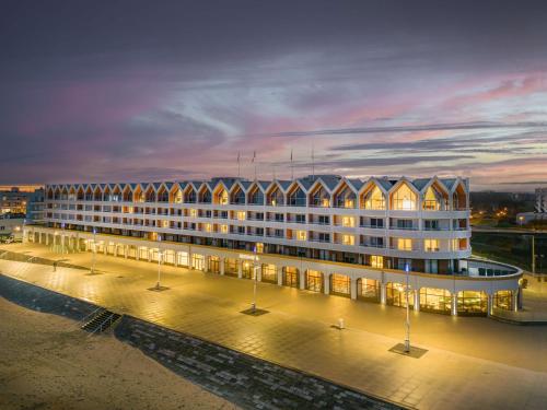 a large building is lit up at night at Radisson Blu Grand Hotel & Spa, Malo-Les-Bains in Dunkerque