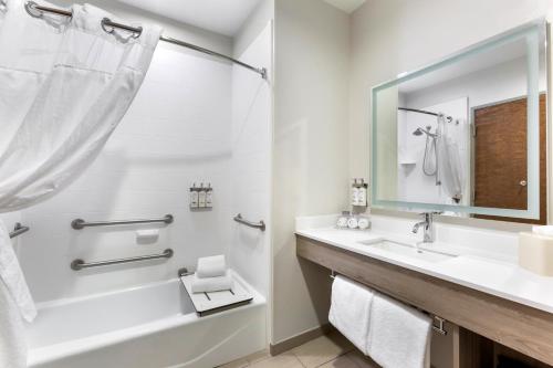 a bathroom with a tub and a sink and a shower at Holiday Inn Express Belgrade-Bozeman Area by IHG in Belgrade