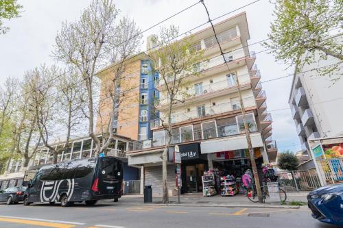 um autocarro estacionado em frente a um edifício alto em Hotel Lily em Rimini