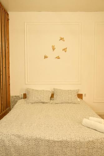 a bedroom with a bed with three birds on the wall at Max Royal in Almaty