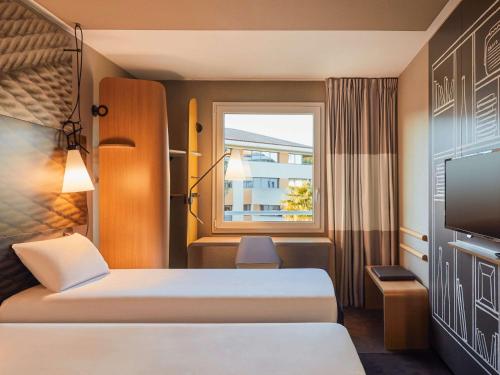 Habitación de hotel con 2 camas y ventana en ibis La Ciotat, en La Ciotat