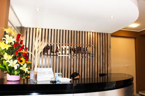 a lobby with a table with flowers and a sign at Hotel PLATINIUM in Tacna