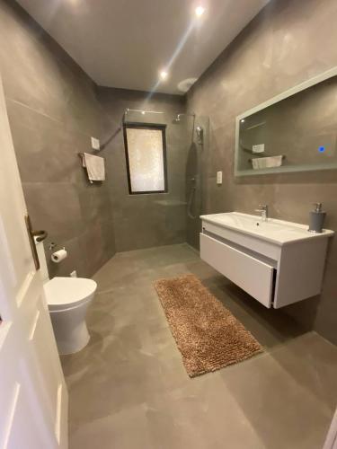 a bathroom with a white sink and a toilet at Gozo Holiday Apartmen - 2 Bedroom Villa with Shared Pool in Xagħra