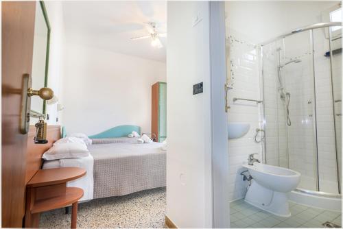 Schlafzimmer mit einem Bett, einer Dusche und einem Waschbecken in der Unterkunft Hotel Lily in Rimini