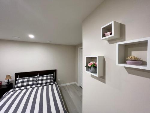 a bedroom with a black and white striped bed and a mirror at Luxury Restful Sleepover Spot in Winnipeg