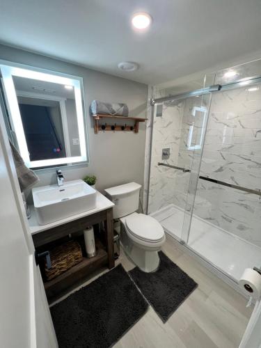 a bathroom with a toilet and a sink and a shower at Luxury Restful Sleepover Spot in Winnipeg