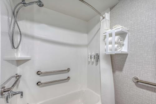 baño blanco con ducha y lavamanos en Hampton Inn New Philadelphia, en New Philadelphia
