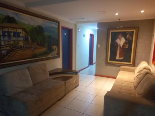 a living room with a couch and a painting on the wall at Pousada Vila Catarina in Ouro Preto