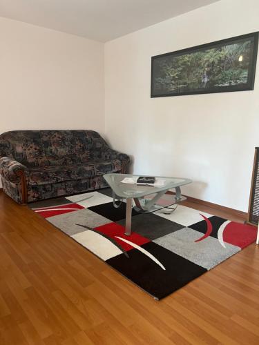 a living room with a couch and a table on a rug at L’Alsace autrement in Soultz-Haut-Rhin