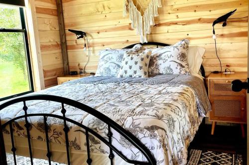 a bedroom with a bed in a log cabin at #4 Kentucky Bourbon Trail Bourbon Barrel Cottages in Lawrenceburg