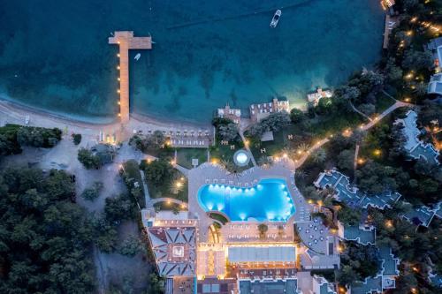 una vista sul mare di un resort con piscina di notte di DoubleTree by Hilton Bodrum Isil Club All-Inclusive Resort a Torba
