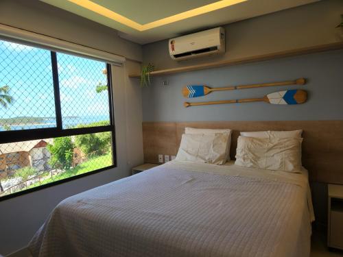 Un dormitorio con una cama grande y una ventana en Eco Resort Praia dos Carneiros - Flat Novo - Ao Lado da Igrejinha, en Praia dos Carneiros