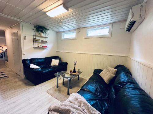 sala de estar con sofá de cuero y mesa en Prestadalen 6, en Sogndal