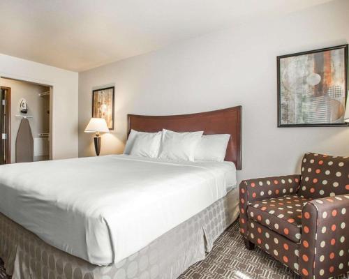 um quarto de hotel com uma cama e uma cadeira em MainStay Suites St Robert-Fort Leonard Wood em Saint Robert