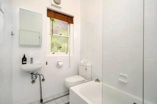 Baño blanco con aseo y lavamanos en HUNT1 - Great Family Unit, Spacious Green Garden en Sídney