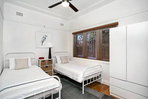 2 camas en una habitación blanca con ventana en HUNT1 - Great Family Unit, Spacious Green Garden en Sídney
