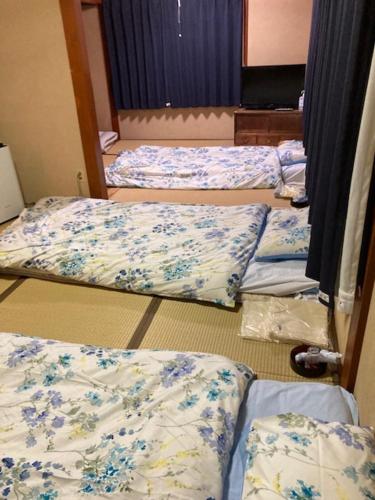 富岡市にあるお宿わいわいのベッド3台が並ぶ客室です。