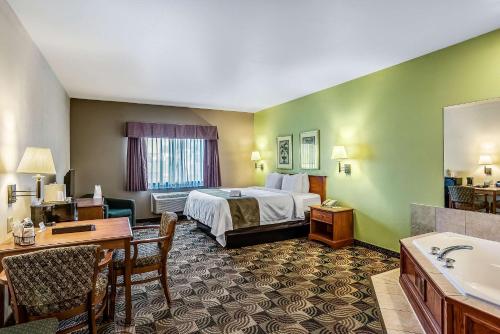 a hotel room with a bed and a desk at Quality Inn & Suites in Hannibal