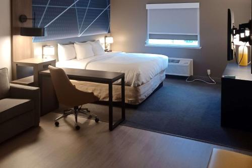 a hotel room with a bed and a desk and a chair at Comfort Inn Edinburgh - Columbus in Edinburgh
