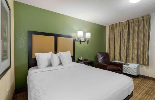 a hotel room with a large bed and a chair at Extended Stay America Suites - Chattanooga - Airport in Chattanooga